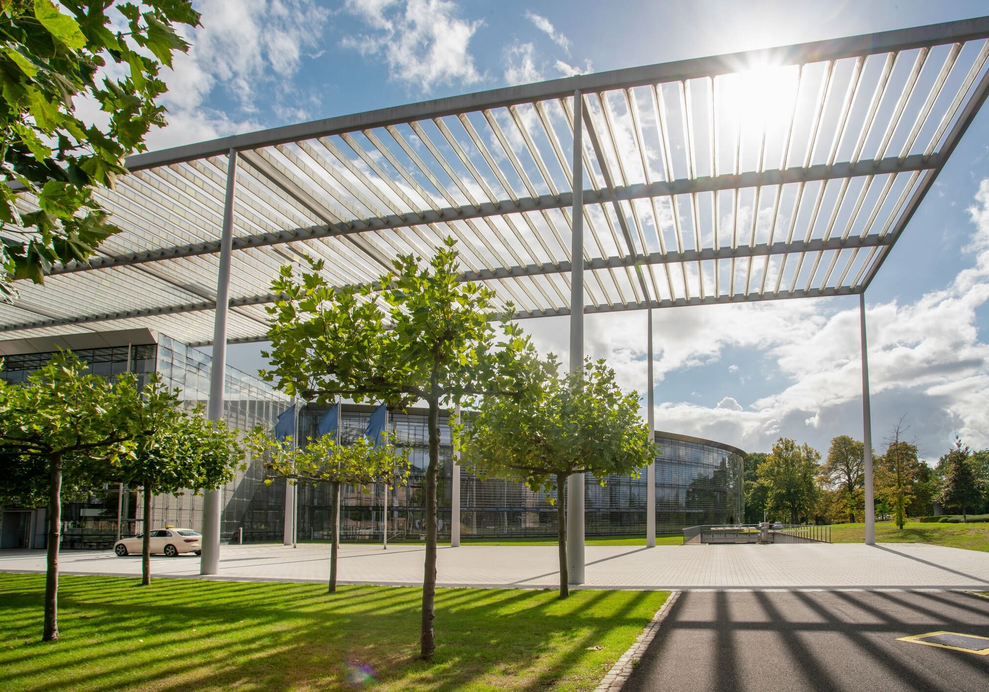 Glass building under a slatted roof structure